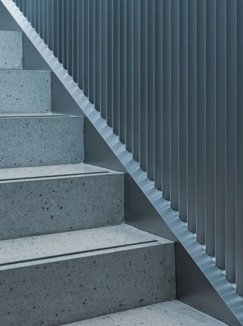 Escalier de terrazzo éclairé à travers des lames verticales